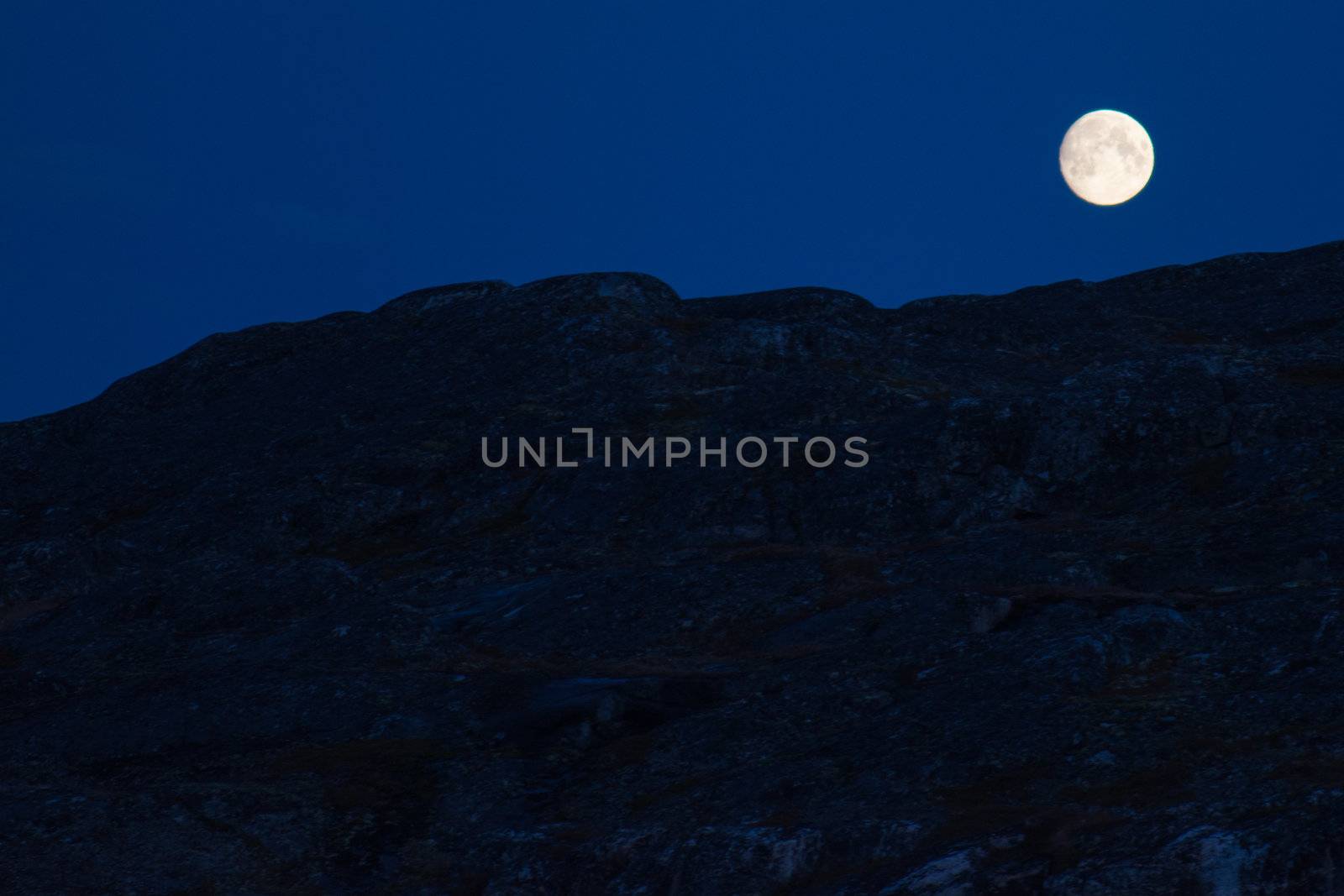 Moon at night with rocky surface in the forground