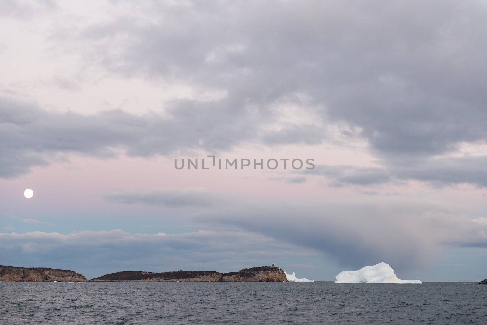 Moon icebergs and dramatic sky ocean landscape in Greenland