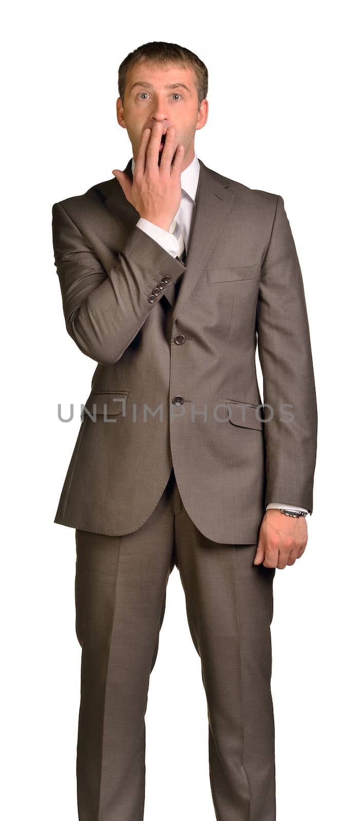 Surprised businessman covering mouth with hand by cherezoff