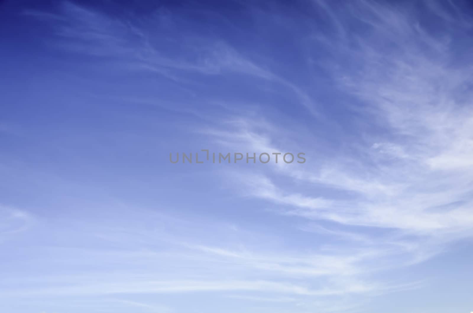 Wispy, thin cirrus clouds against blue sky