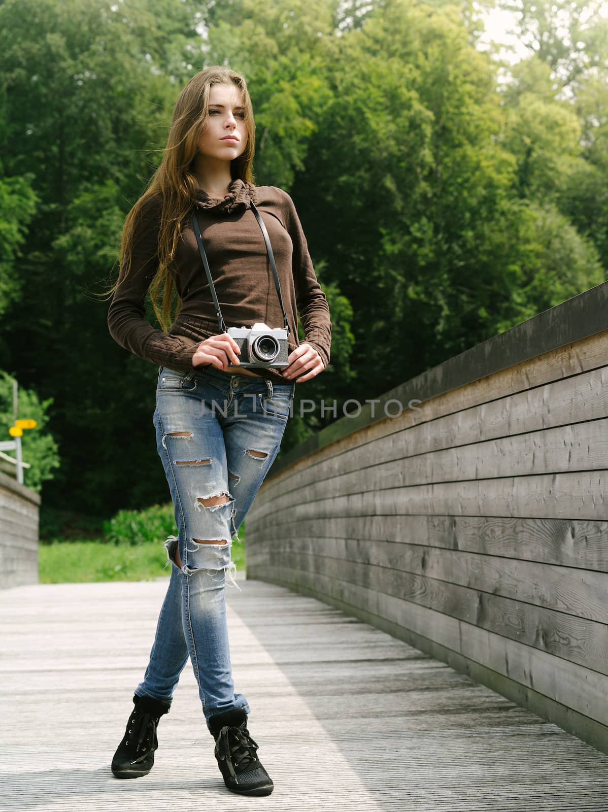 Beautiful woman outdoors with vintage camera by sumners