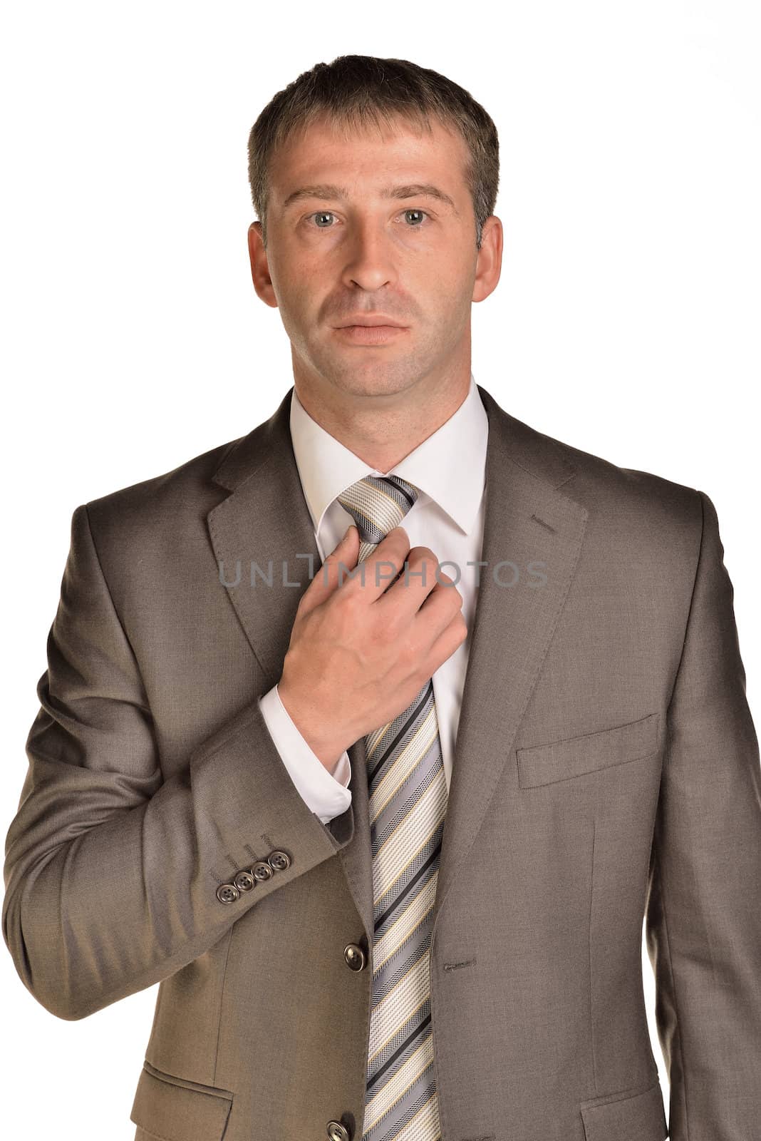 Businessman corrects his tie. Isolated on white