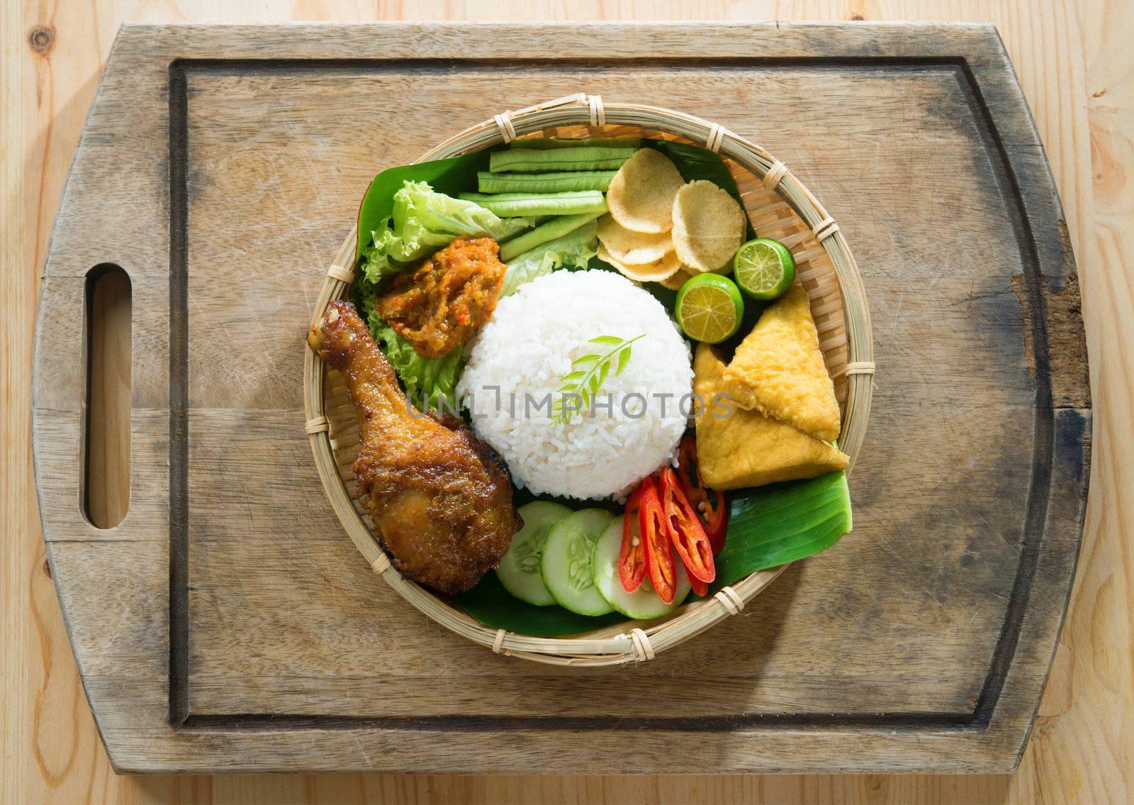  Delicious nasi ayam penyet with sambal belacan. Fried chicken rice with overhead view. Famous traditional Indonesian food.