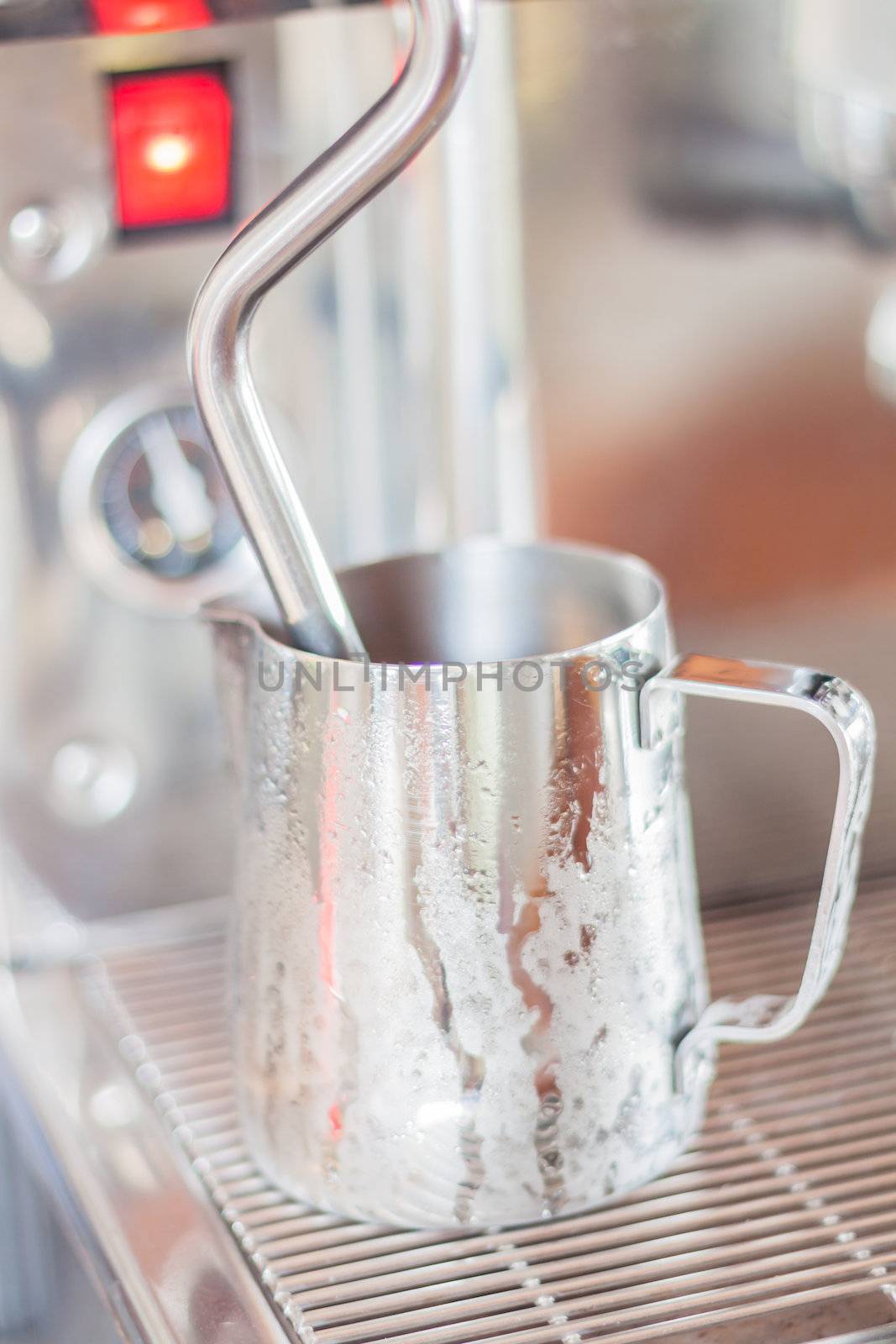 Prepares pitcher for steaming milk, stock photo