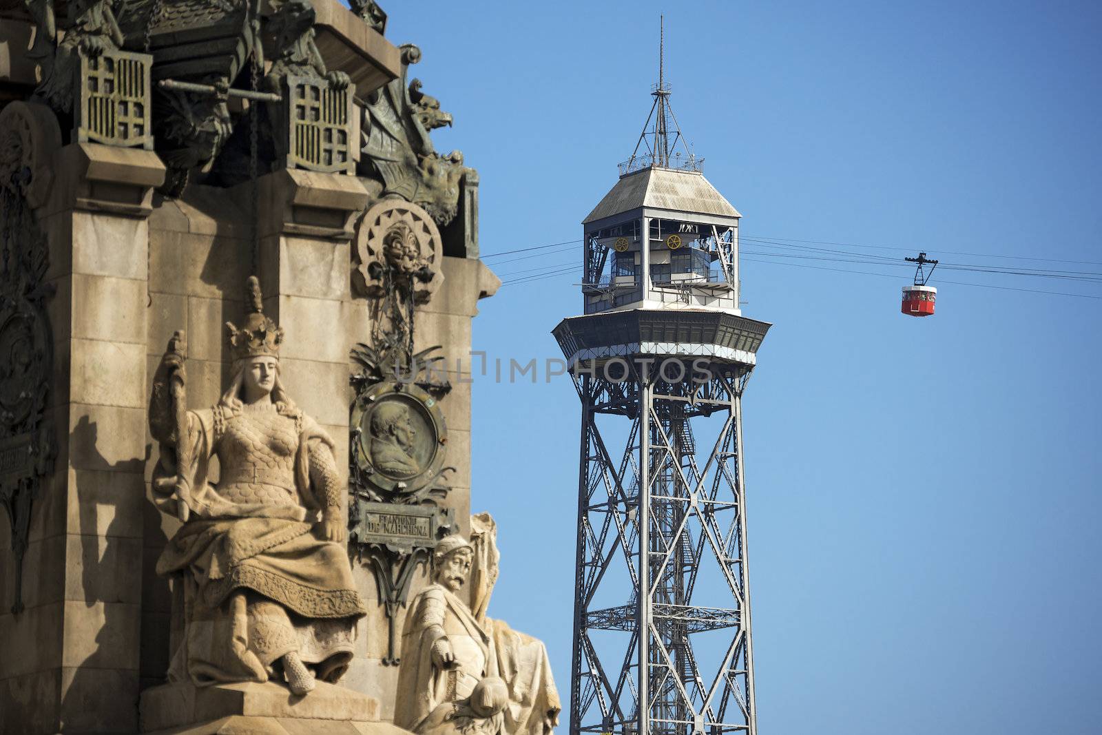 Cable car from Montjuic in Barcelona, Spain with iron tower, in the foreground (blurred) the Monument to Christopher Columbus