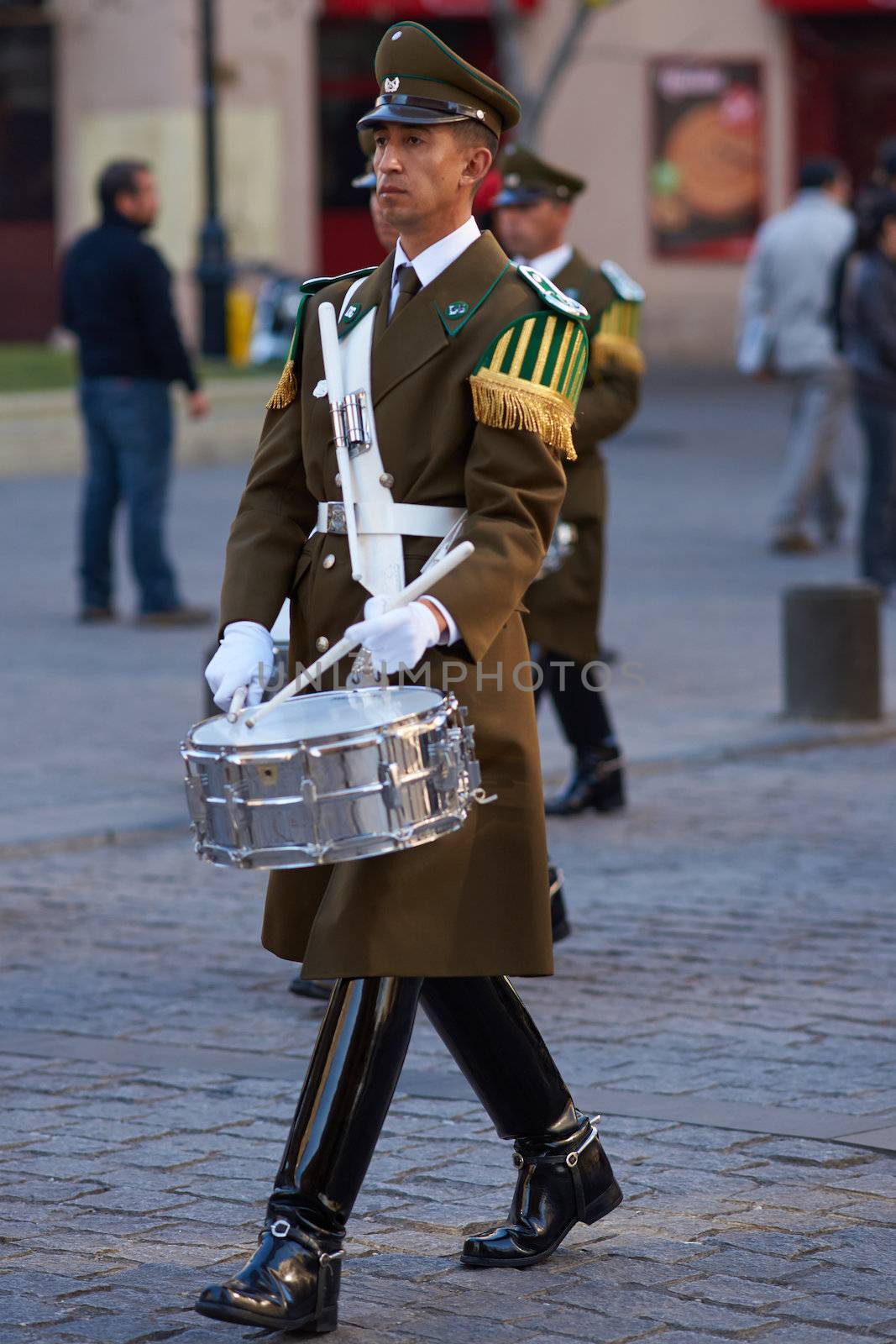 Member of the Carabineros Band marching and playing the drum as part of the changing of the guard ceremony at La Moneda in Santiago, Chile