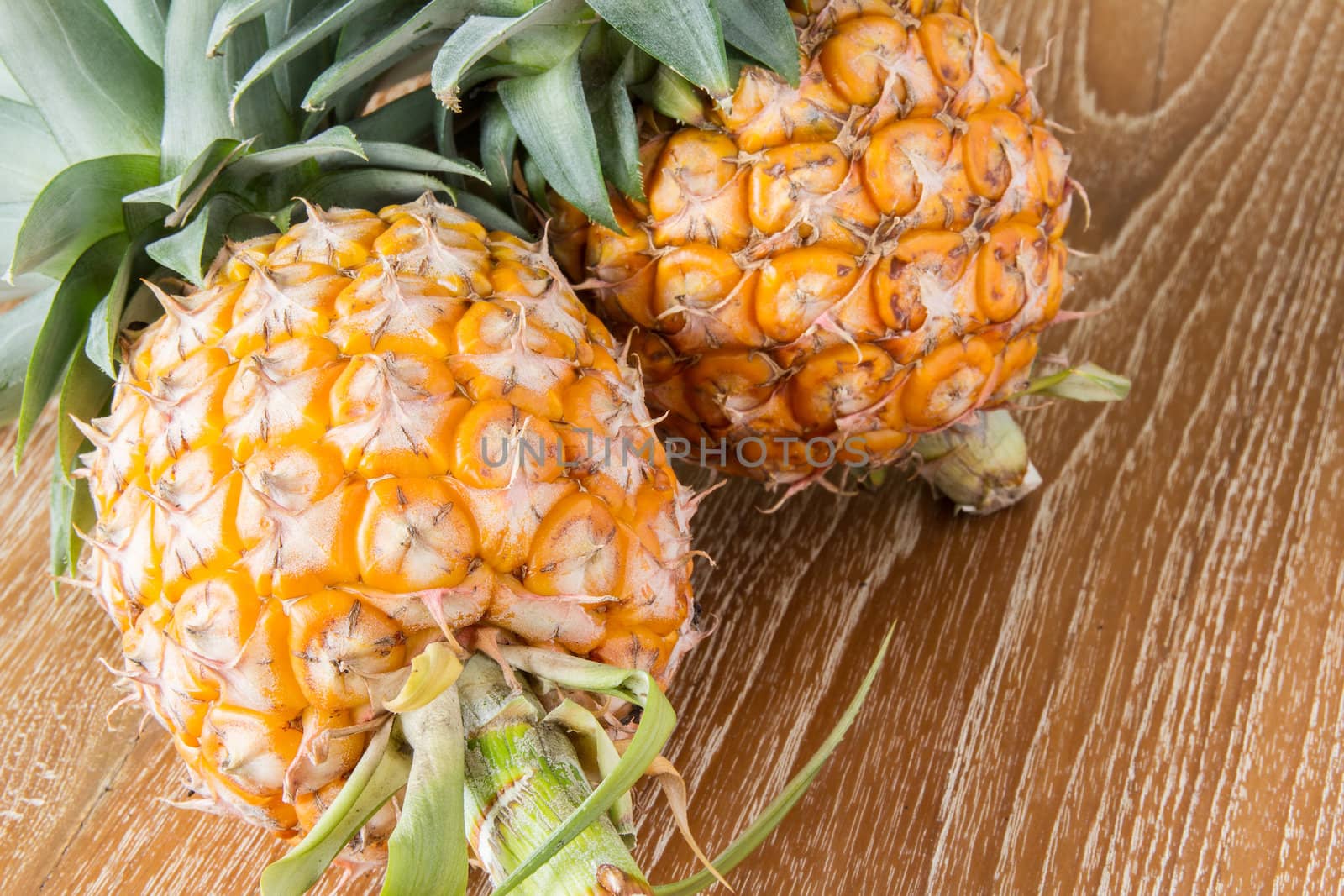 Pineapple on wood table by kasinv