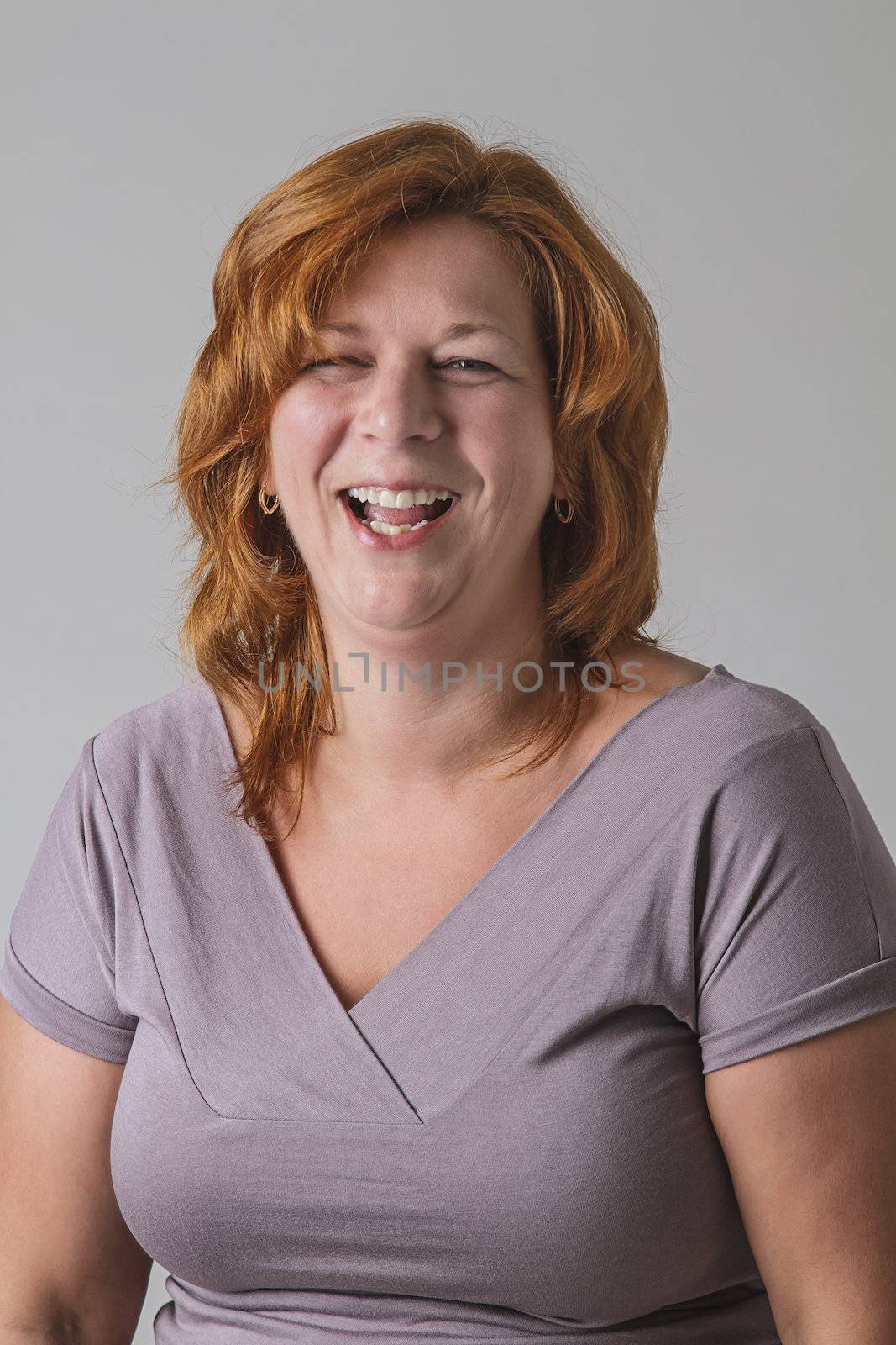 Red hair woman in her forties laughing out loud