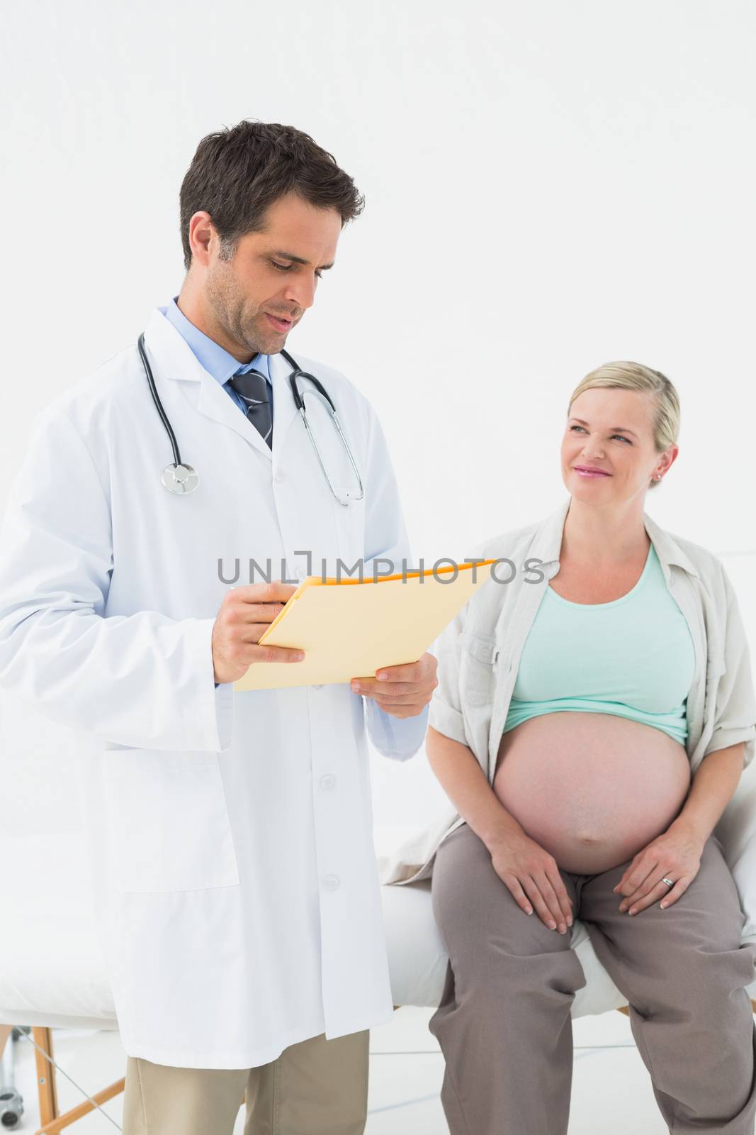 Cheerful pregnant woman having a check up with doctor at the hospital