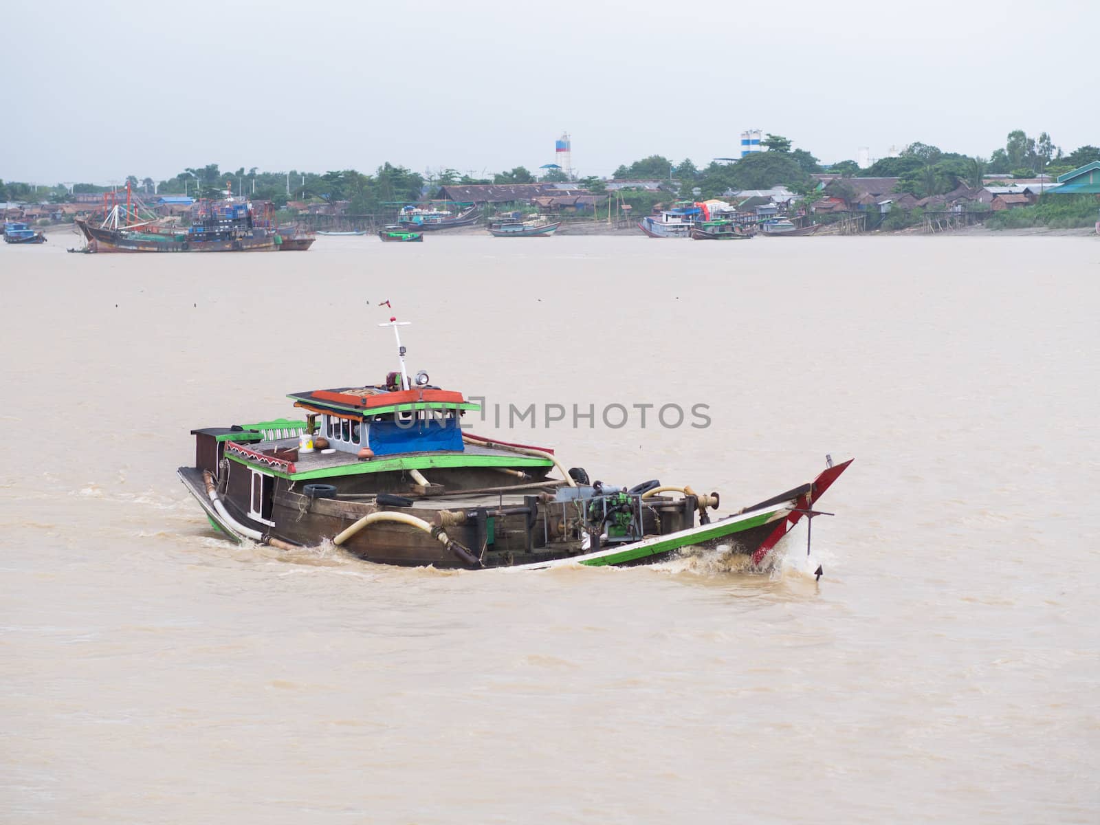 Traditional, wooden Burmese cargo vessel, fully loaded, on Yangon River.
