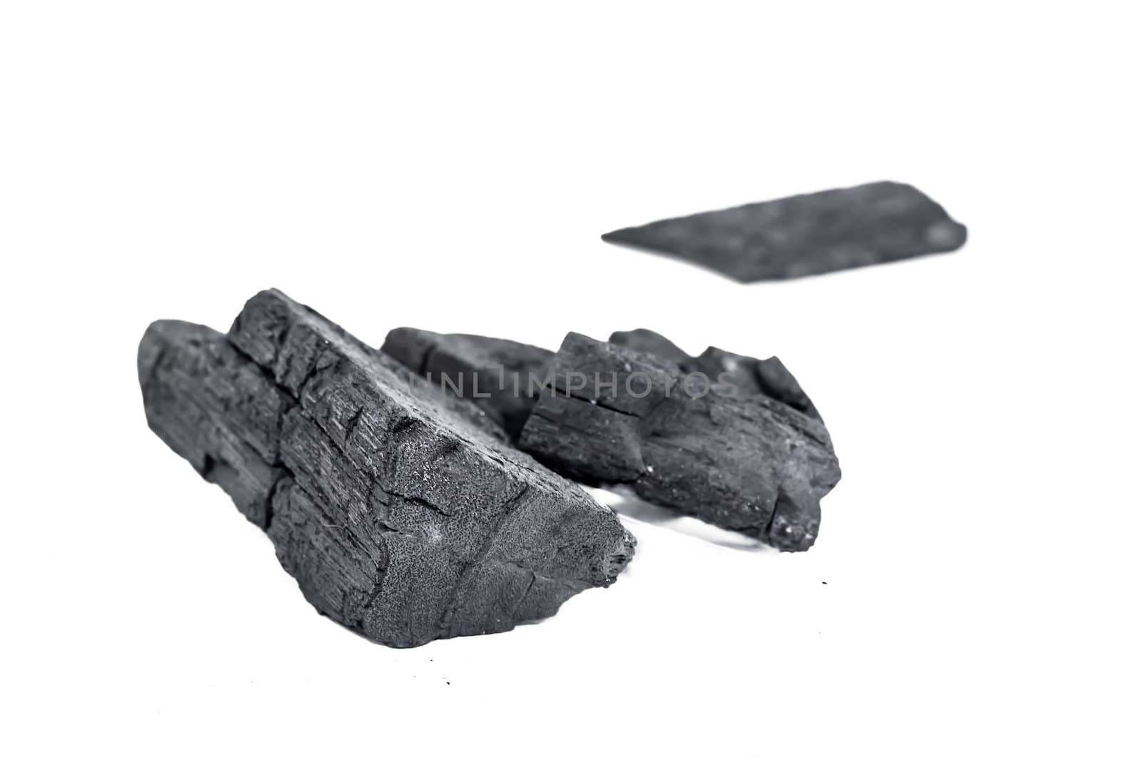 many pieces of charcoal isolated on white background by wmitrmatr