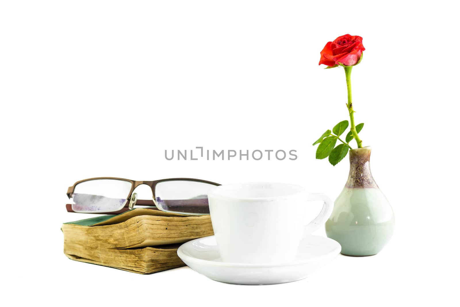 still life white cup and pink zinnia book and glasses on a white background