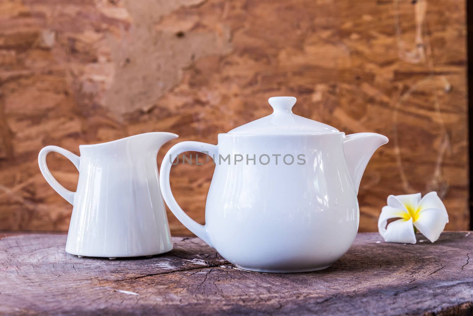 white tea pot on wood background by wmitrmatr