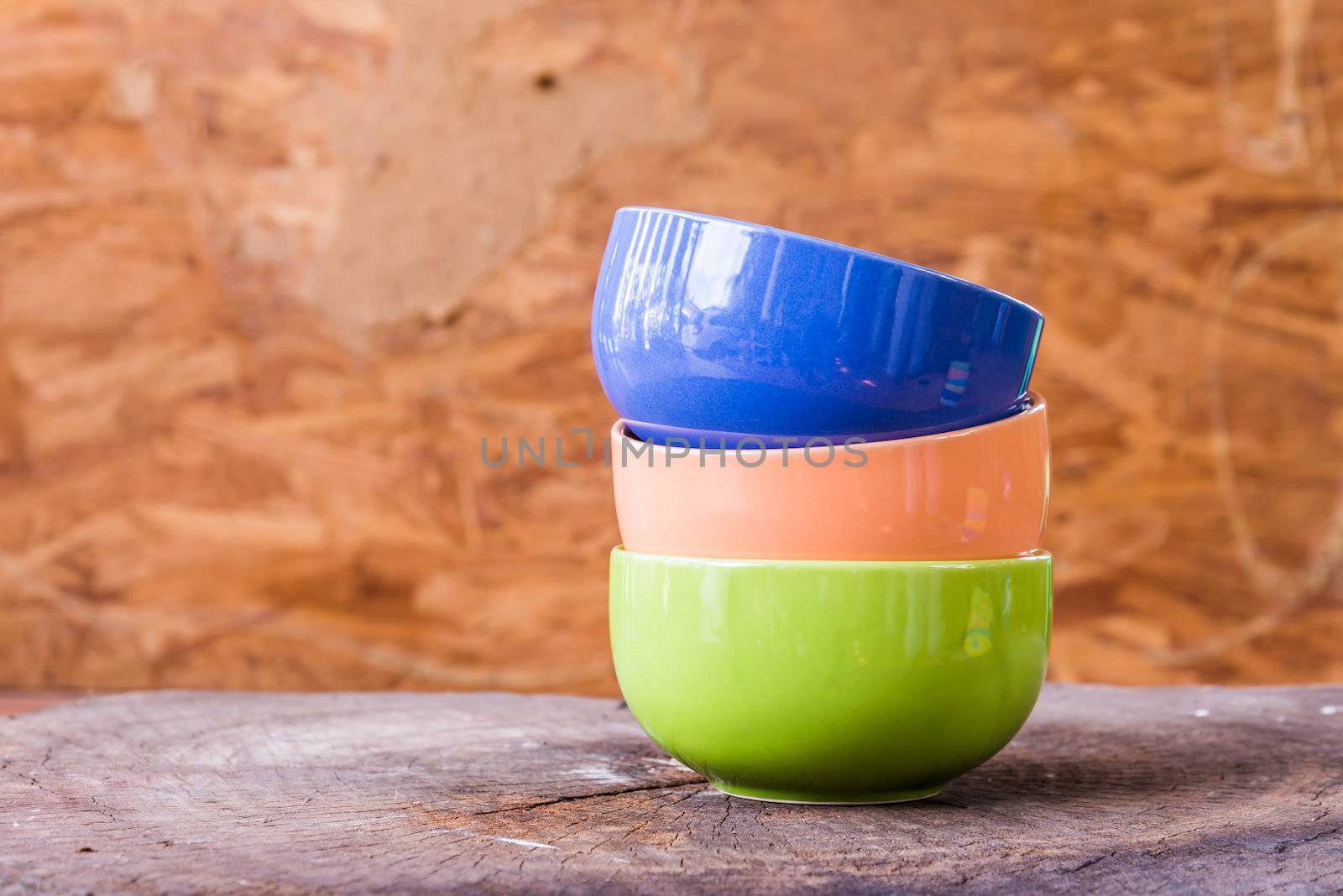 Beautiful color cups on wood background by wmitrmatr