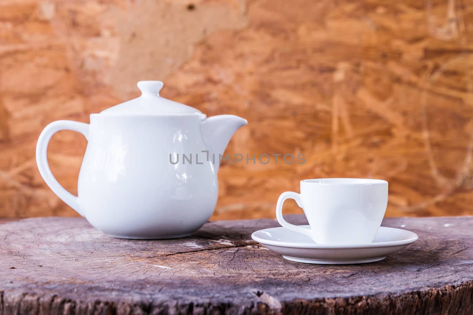 White cup with white tea pot on wood background by wmitrmatr