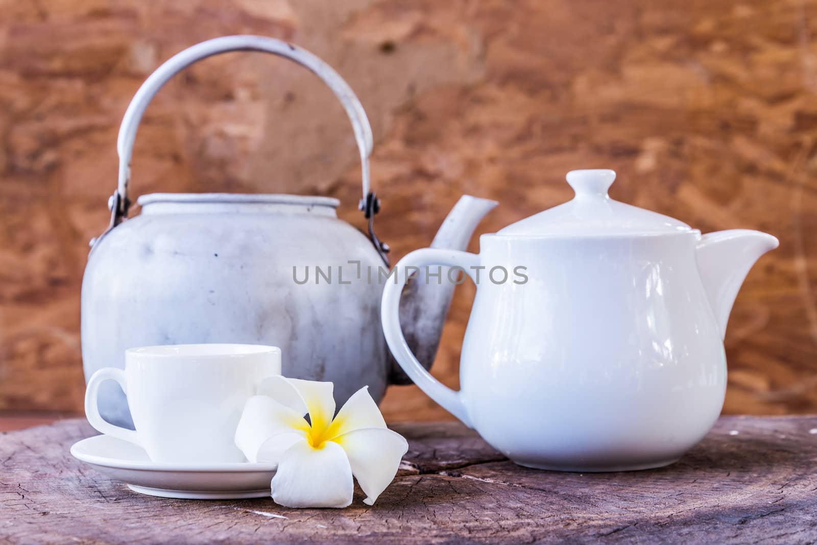 frangipani and White cup with white tea pot on wood background by wmitrmatr