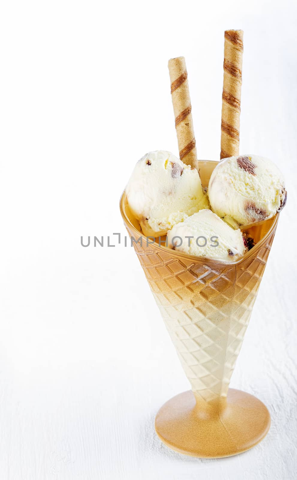 Vanilla ice cream  with wafer in cup on white wooden background