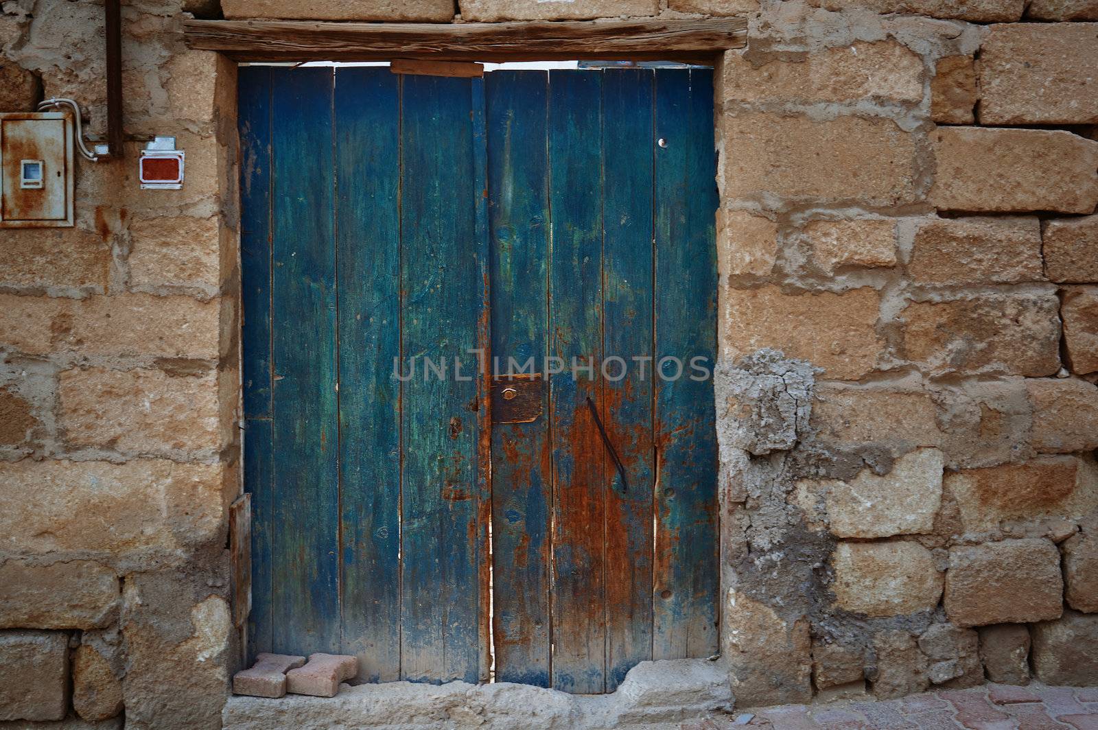 Old door in stony fence. Horizontal photo
