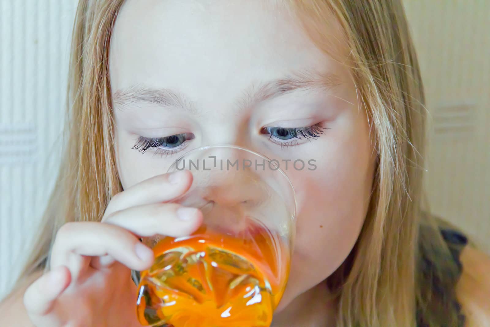 Cute girl with blond long hair drinking beverage