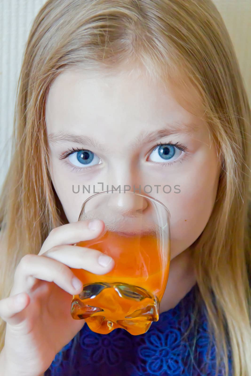 Cute girl with blond long hair drinking beverage