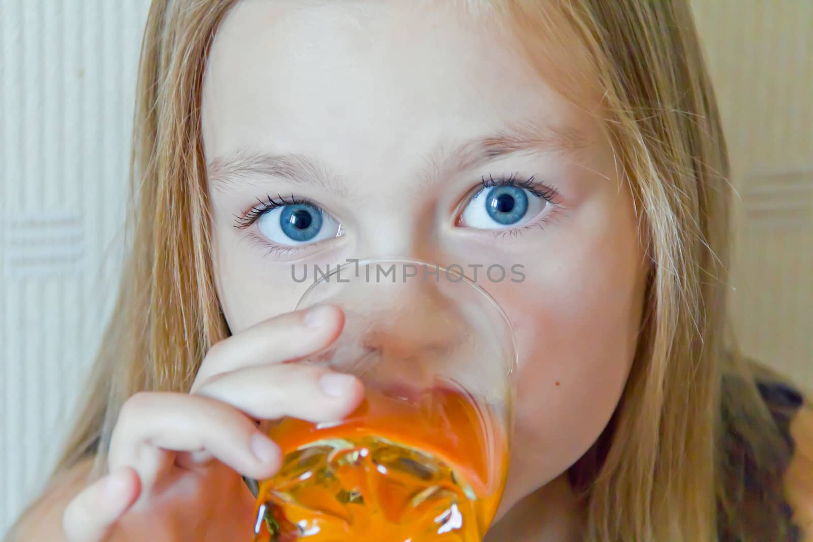 Cute girl with blond long hair drinking beverage