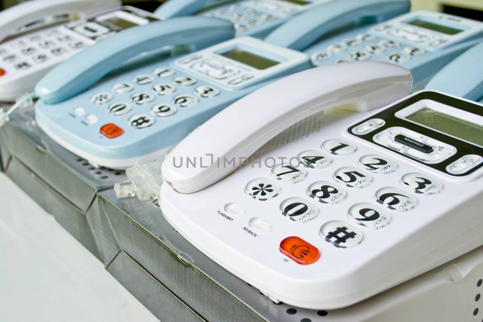 Set of telephones on a desk, receiver close-up by Thanamat