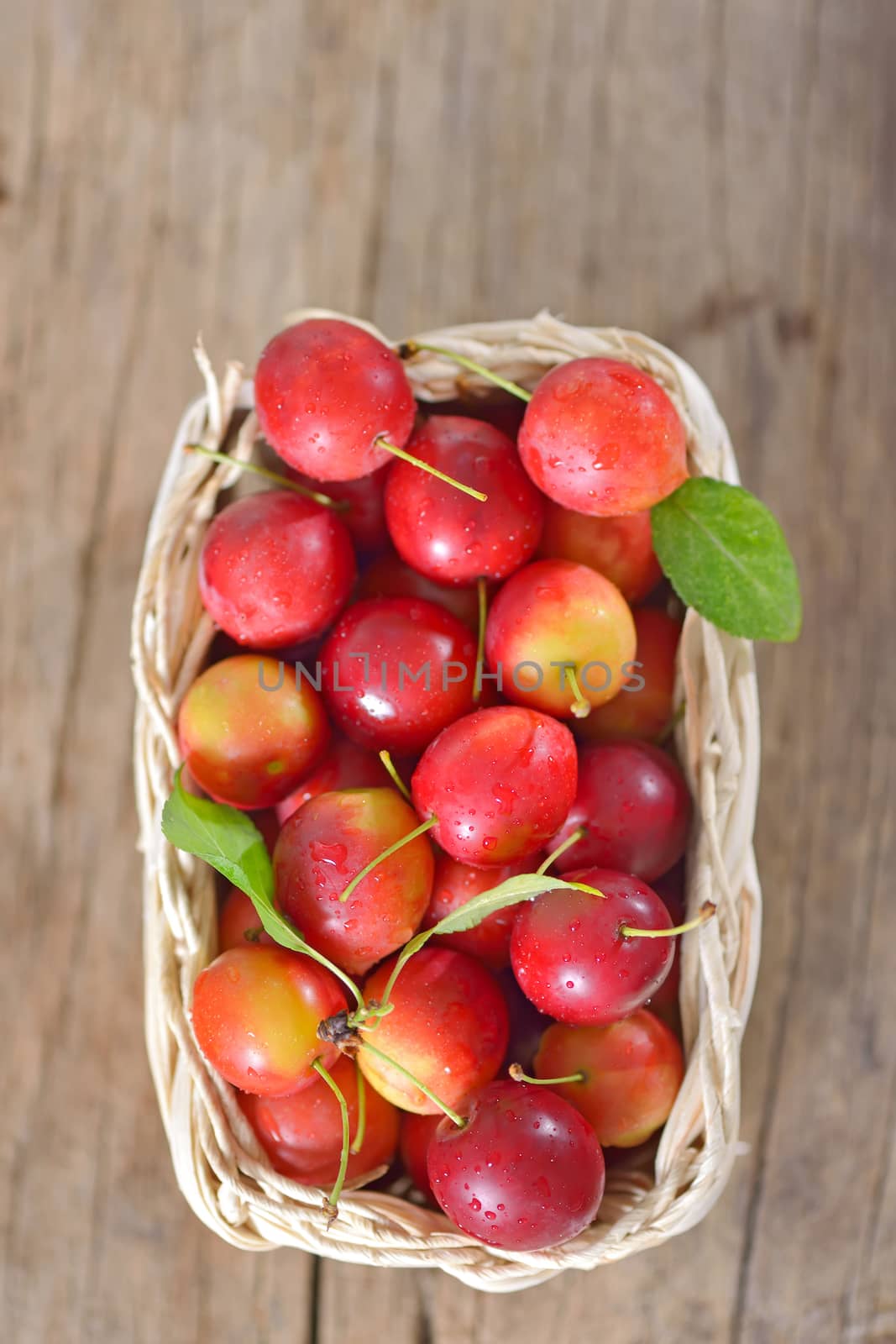 cherry-plum in basket on wooden background