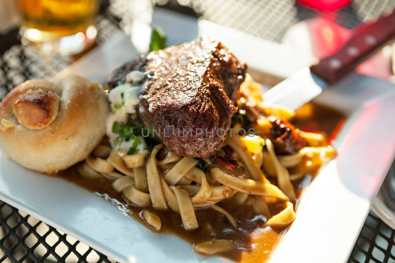 Petite filet mignon on a bed of homemage pasta with mushrooms and truffle oil.  Shallow depth of field. 