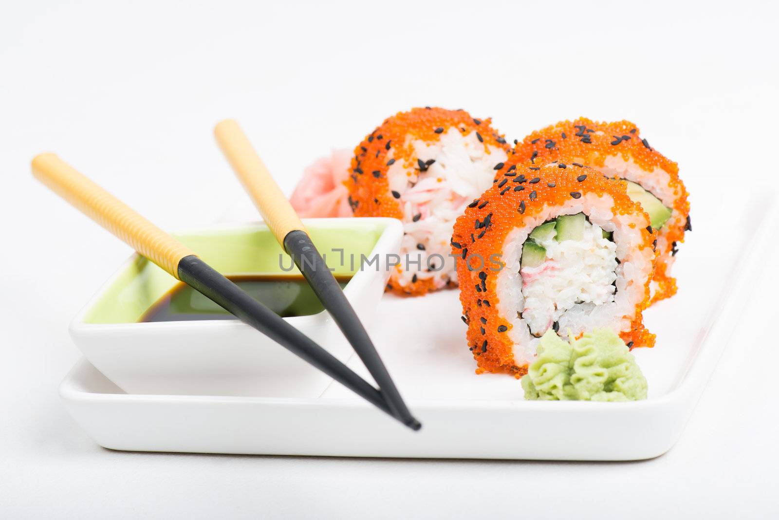 Chopsticks and sushi on the plate, light background