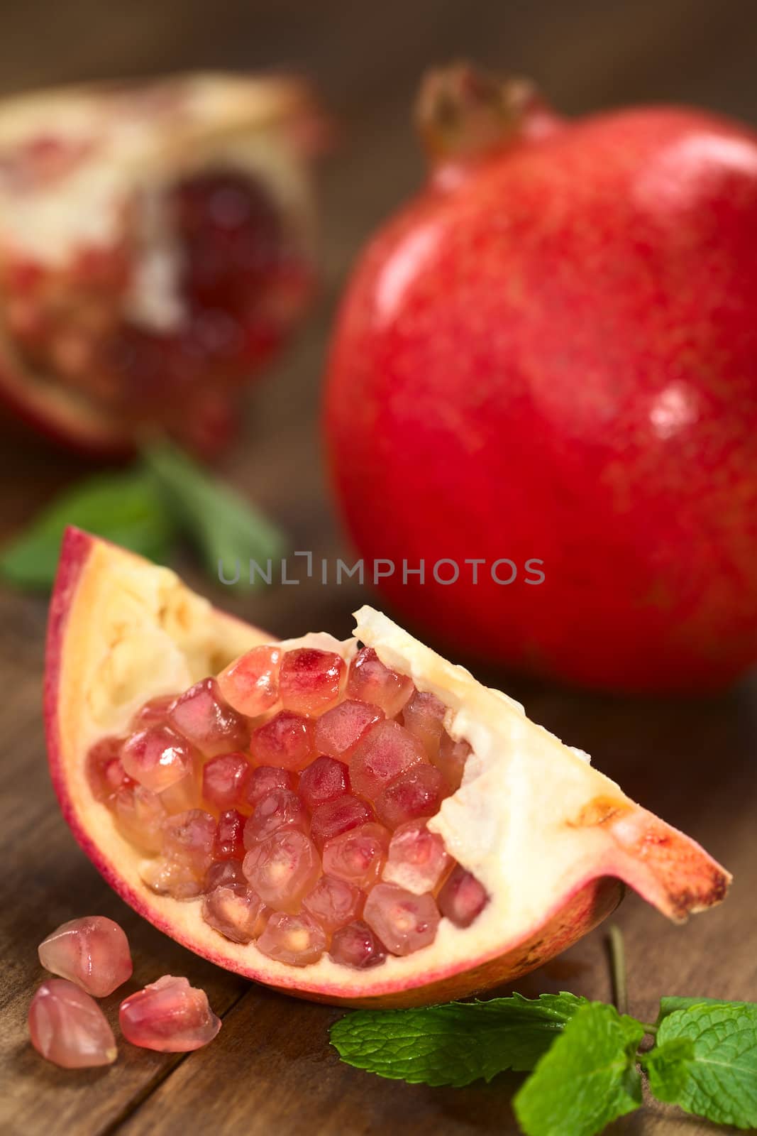 Open pomegranate fruit (lat. Punica granatum) with seeds (Selective Focus, Focus on the upper seeds)