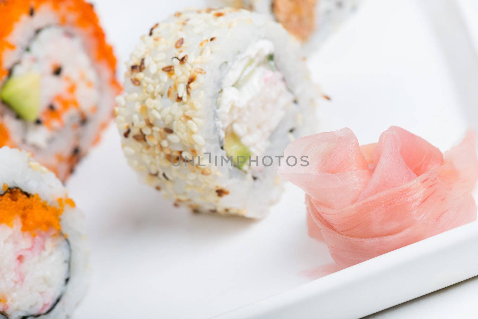 Rose from ginger and sushi rolls on the background