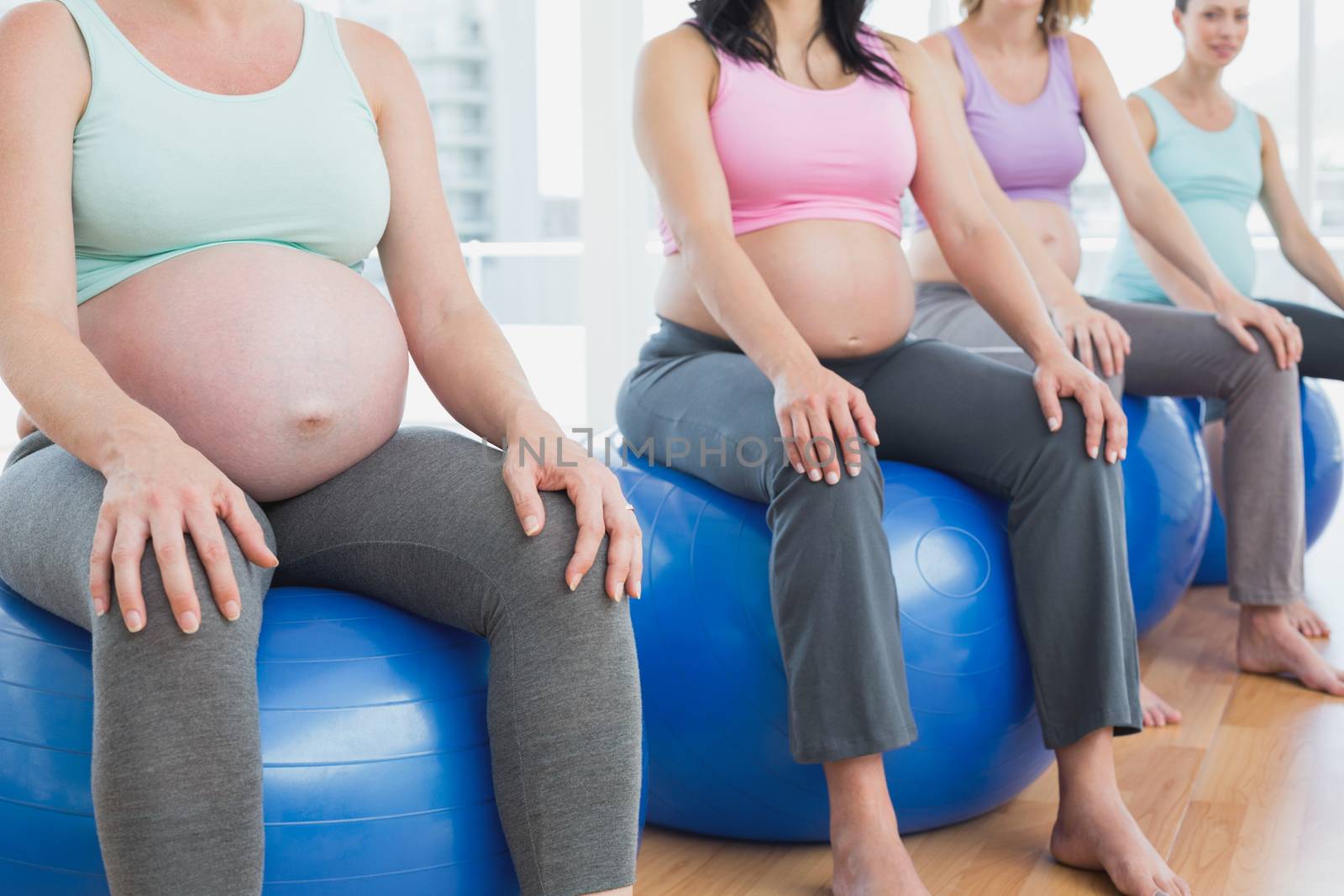 Pregnant women sitting on exercise balls by Wavebreakmedia