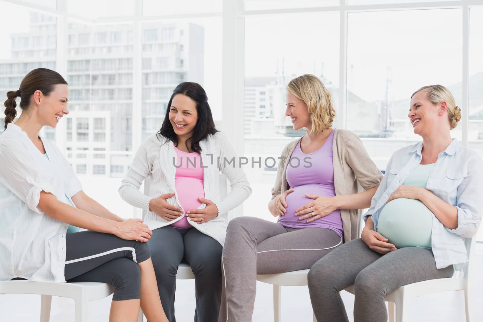 Happy pregnant women talking together at antenatal class at the hospital
