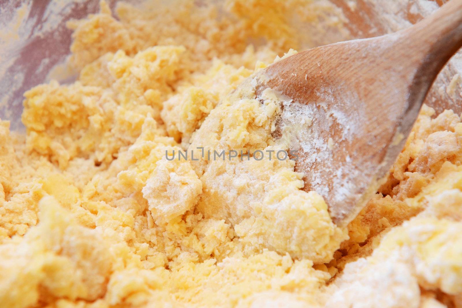 Creaming butter and powdered sugar together with a wooden spoon
