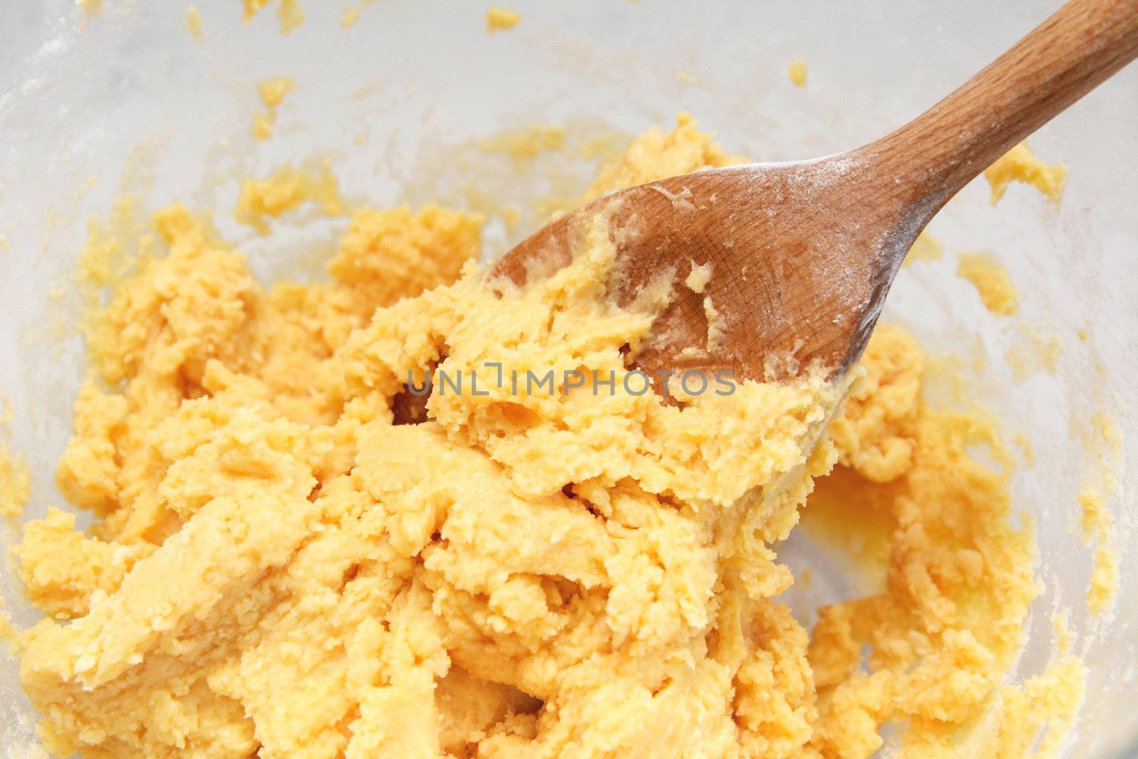 Butter and flour creamed together in a glass bowl with a wooden spoon