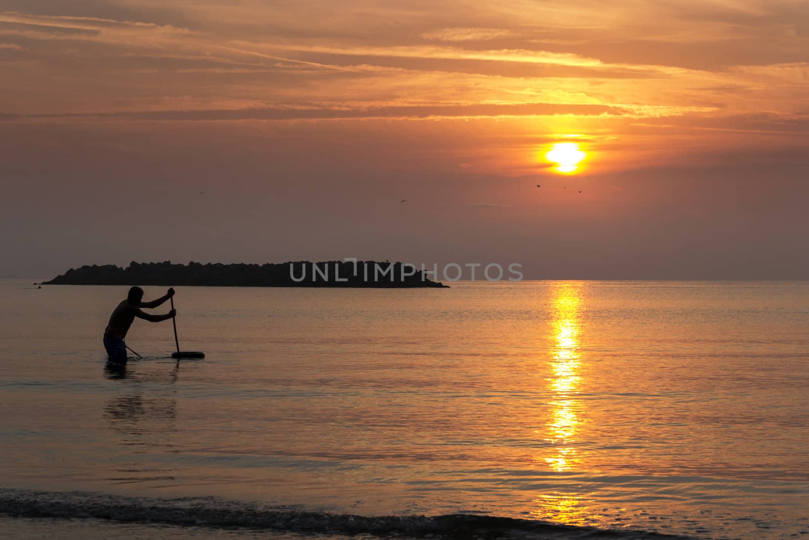 Fishing man in the sea during the sunrise by enrico.lapponi