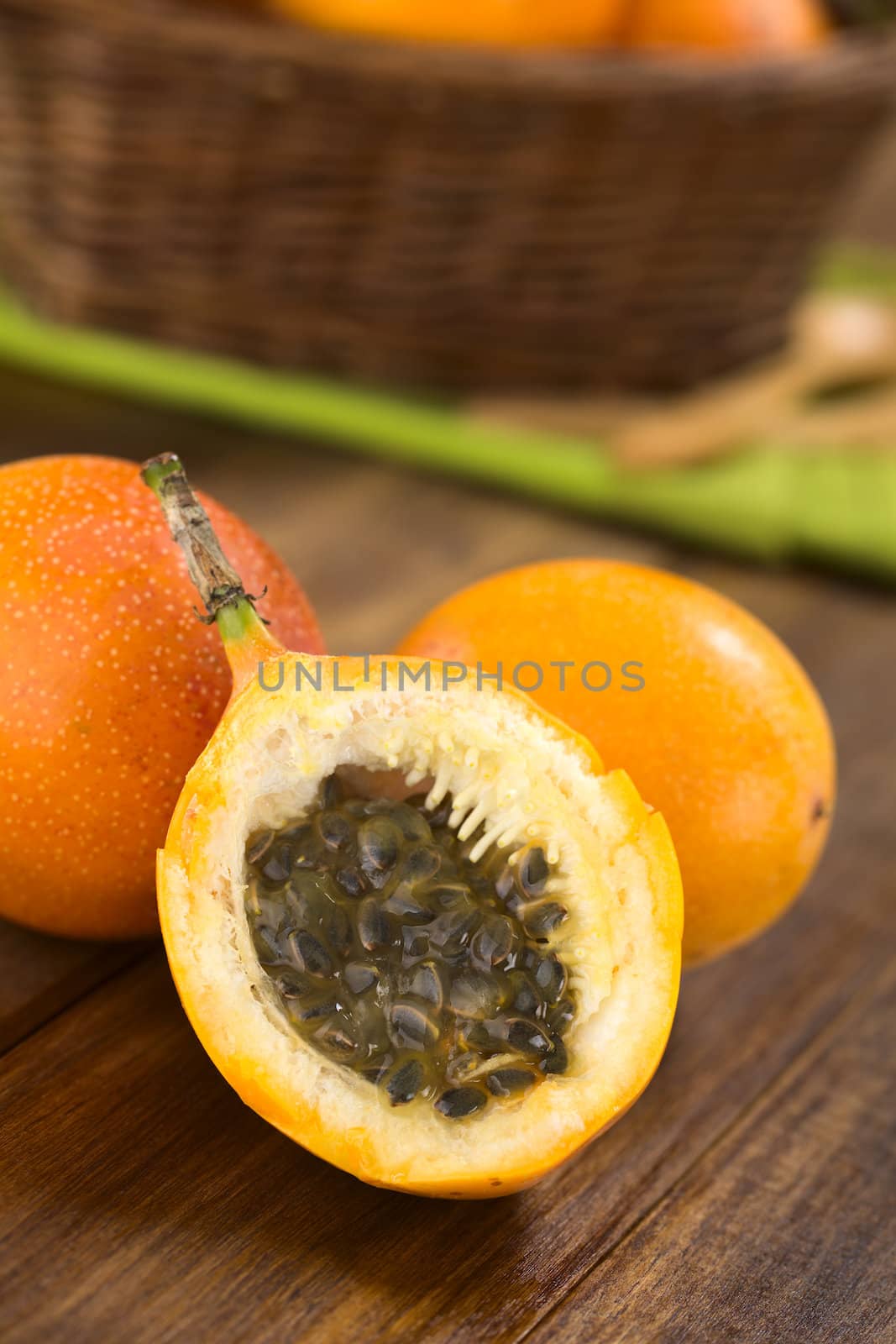 Sweet granadilla or grenadia (lat. Passiflora ligularis) fruit cut in half,  of which the seeds and the surrounding juicy pulp is eaten or is used to prepare juice  (Selective Focus, Focus on the front of the seeds)