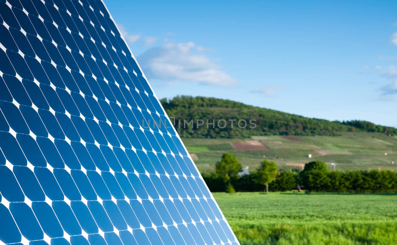 Solar Panel With Green Landscape Against The Blue Sky