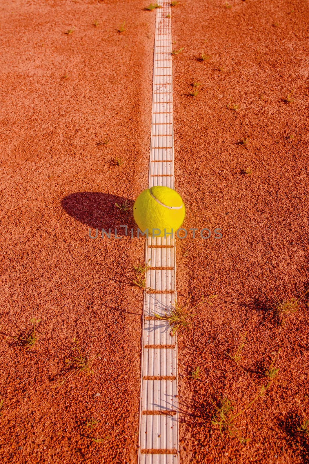 Yellow tennisball on a old court by Sportactive