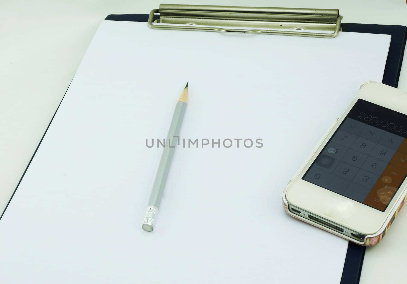 The white paper laid on board for writing notes. Top with a pencil and calculator.                               