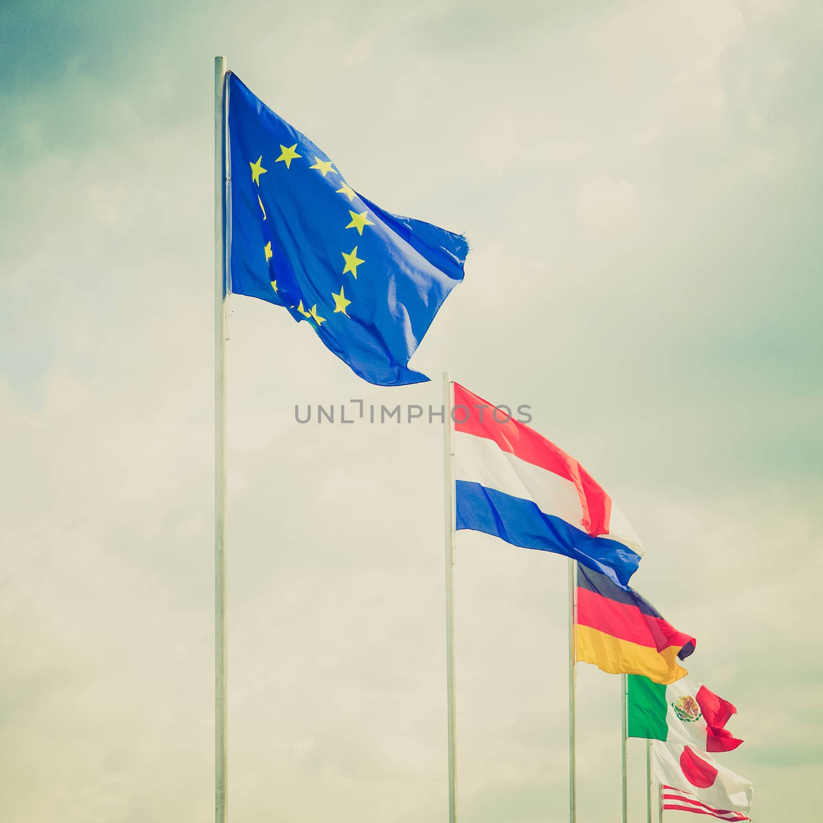 Vintage retro looking Range of flags over a blue sky