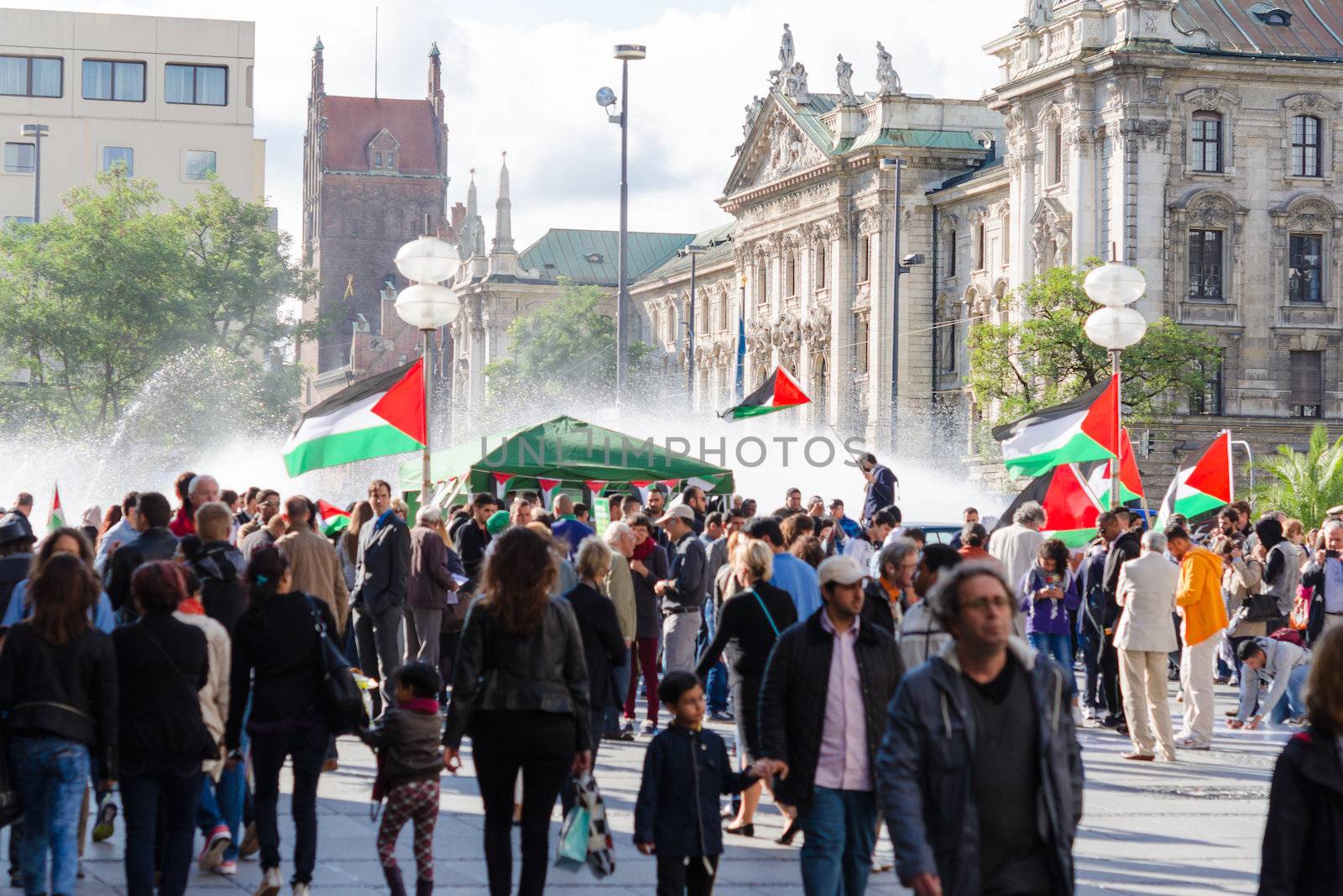 MUNICH, GERMANY - AUGUST 16, 2014: Palestinian demonstration in the center of a major European city. Activists with flags require a peaceful solution to the Arab-Israeli conflict and stop the bombing of Gaza.