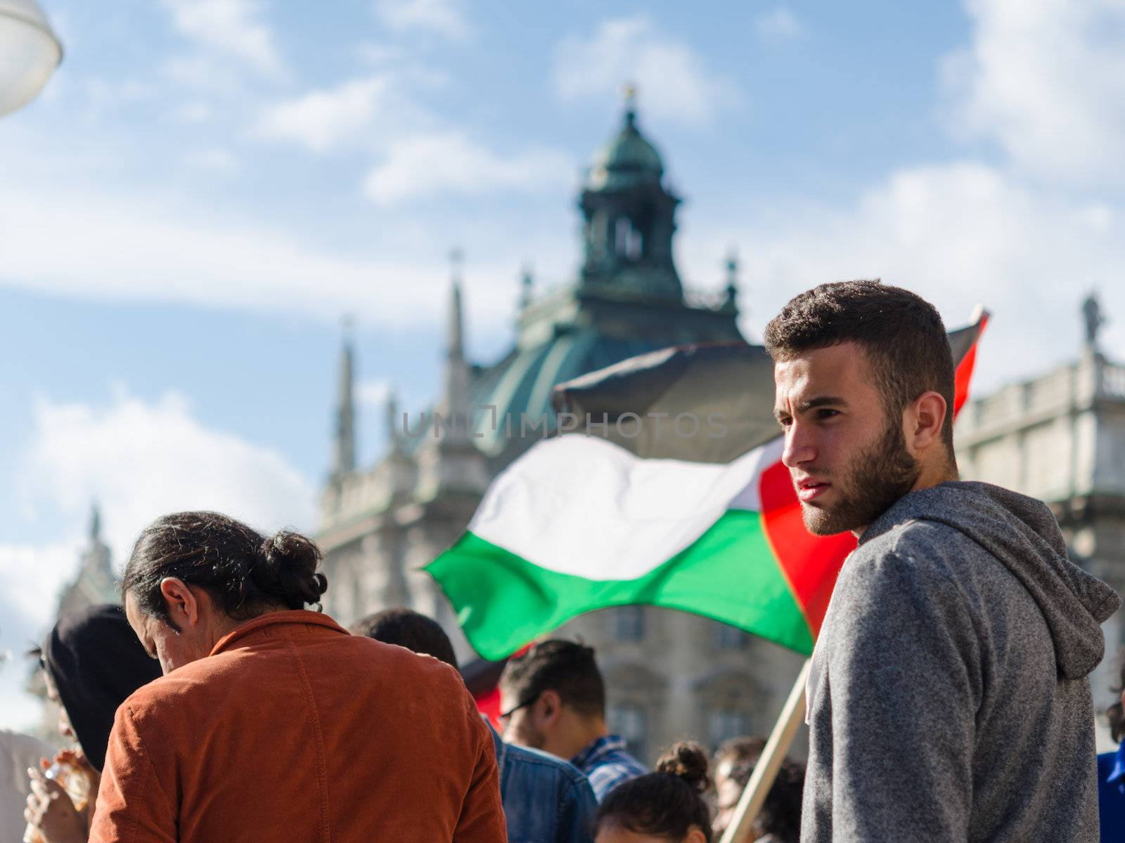 MUNICH, GERMANY - AUGUST 16, 2014: Face of a young activist on the background of the Palestinian flag. Pacific demonstration in support of the Gaza Strip population. For peace, freedom, independence and against a war.