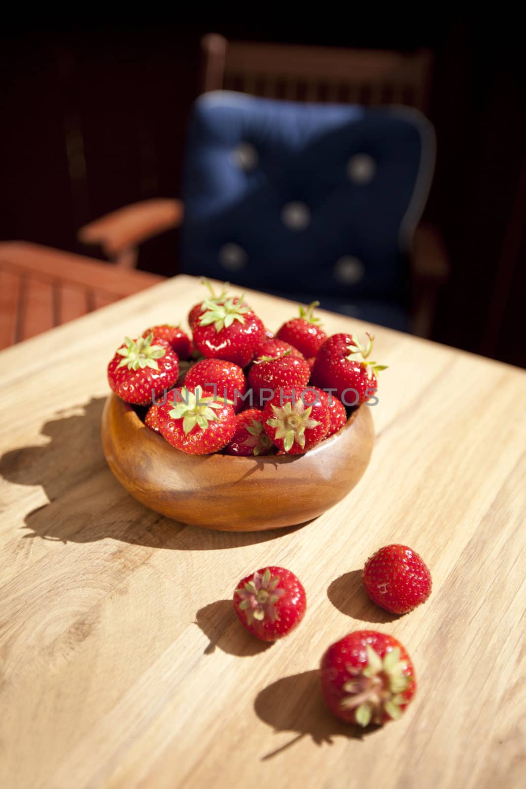 Fresh strawberries in wood bowl on table