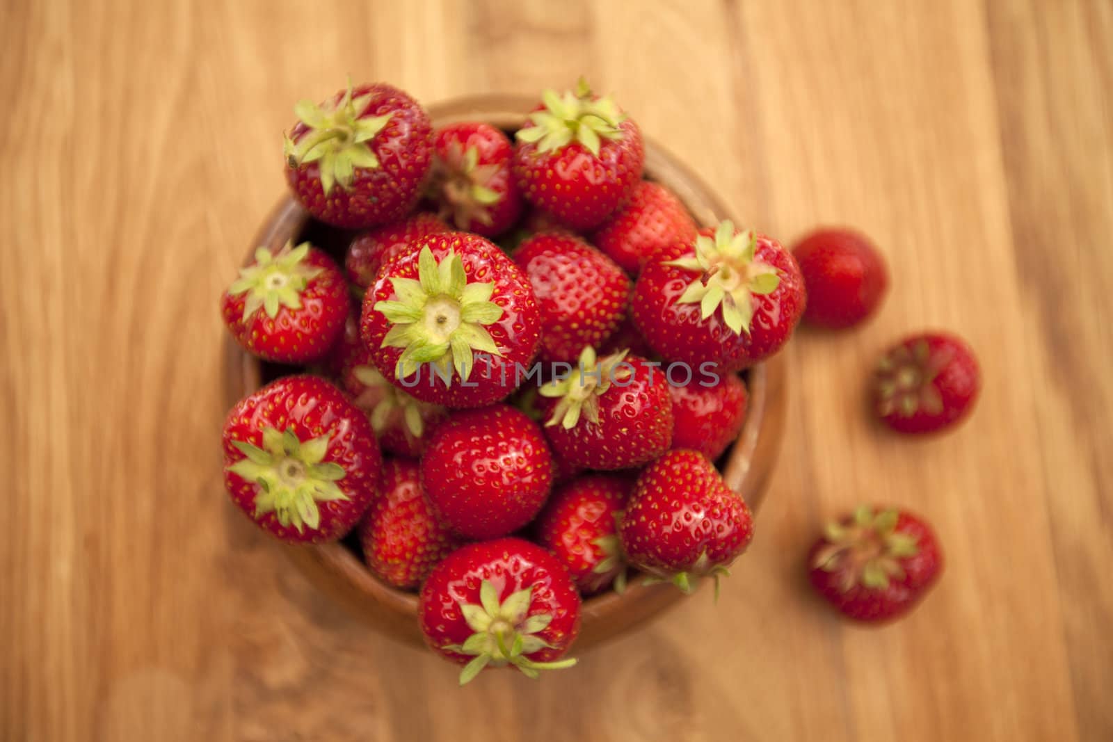 Fresh strawberries in wood bowl on table