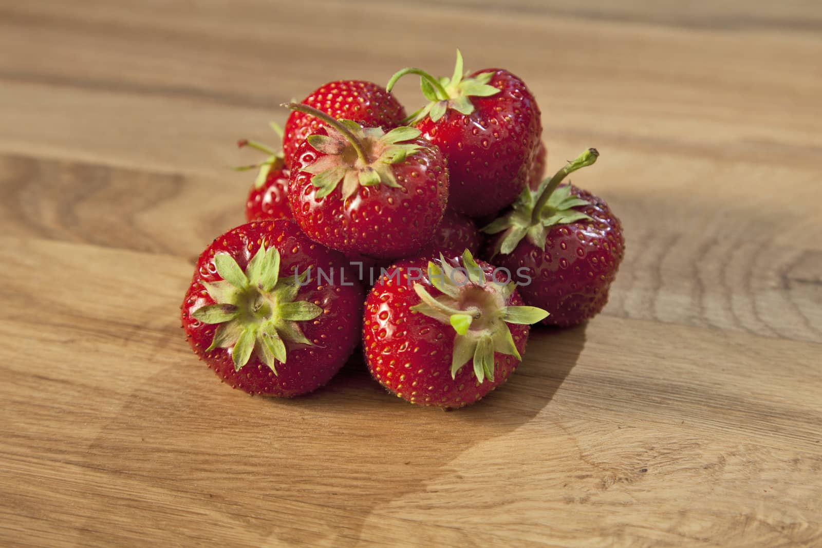 Fresh ripe red strawberries on wooden textured table top