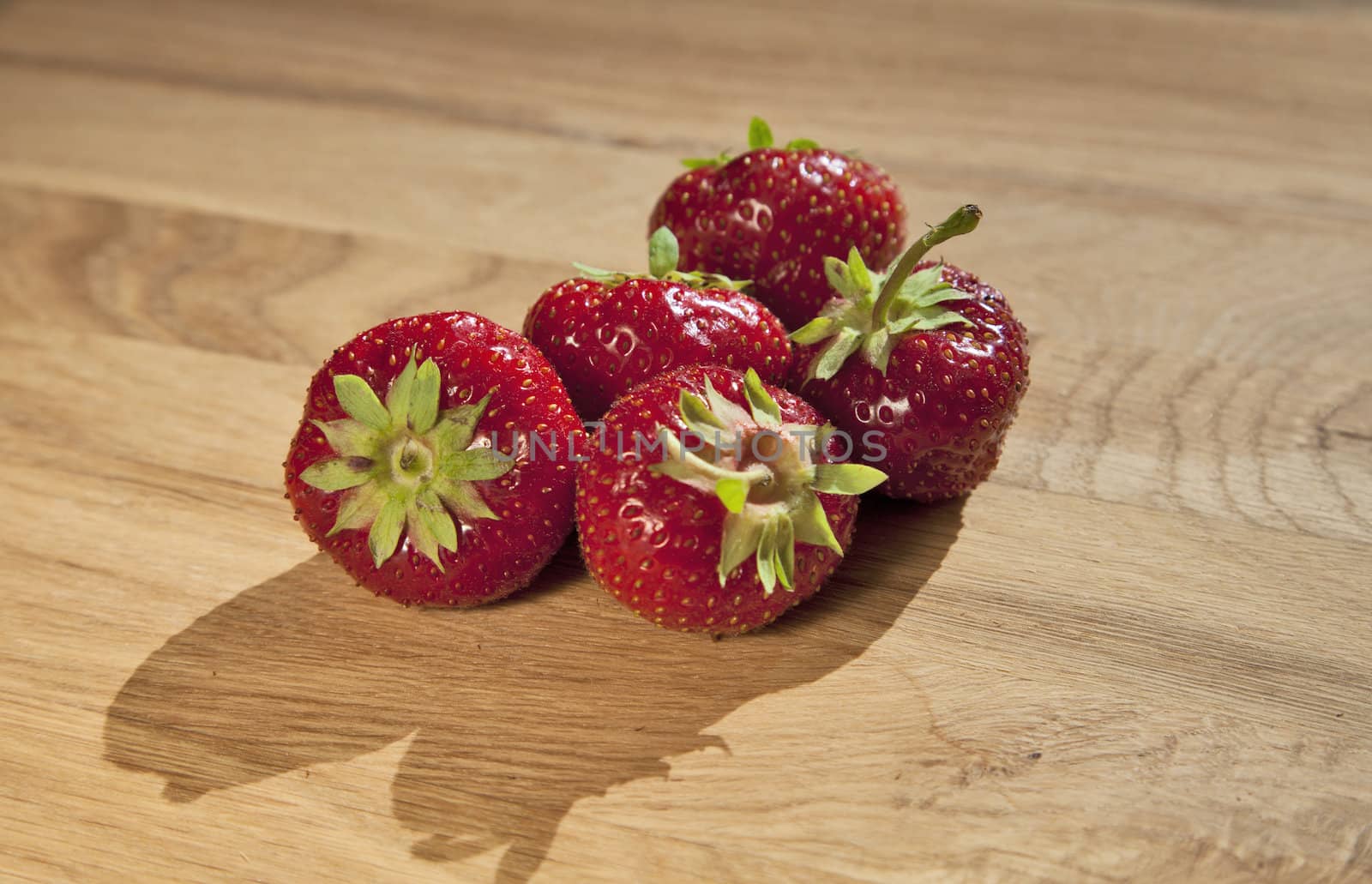 Fresh ripe red strawberries on wooden textured table top