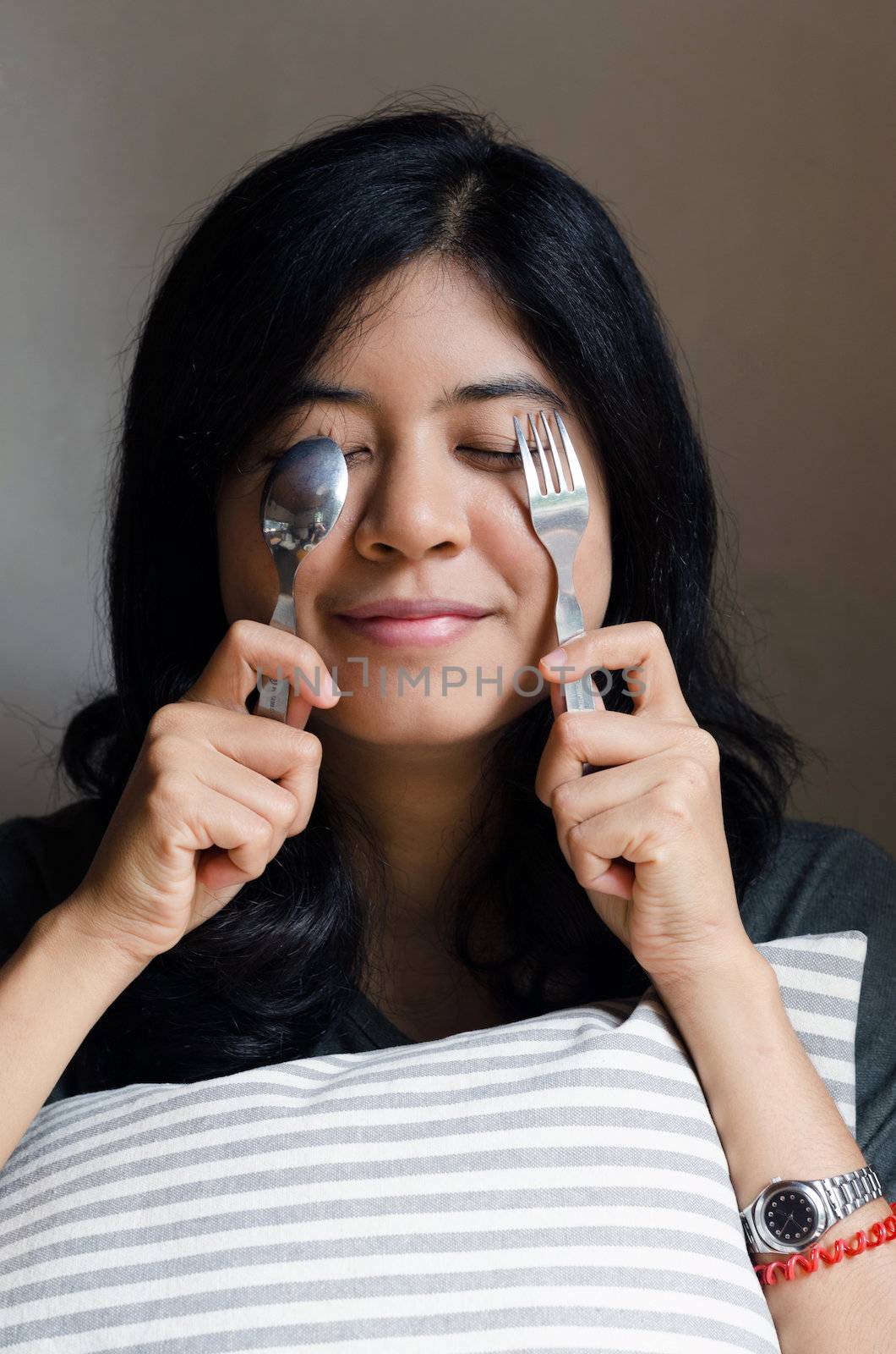 Funny asian woman with spoon and fork