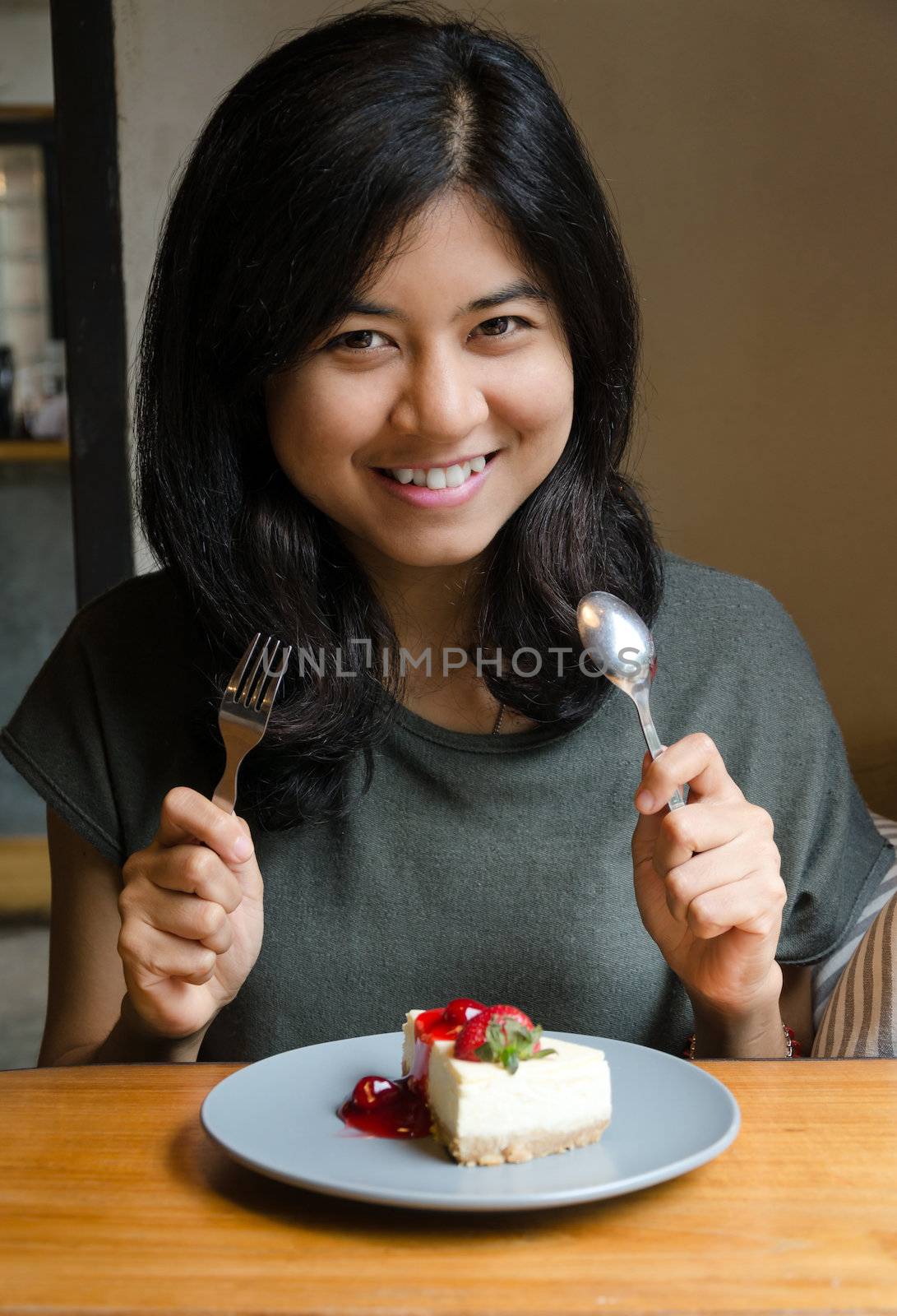Young beautiful woman with a cake in cafe by siraanamwong