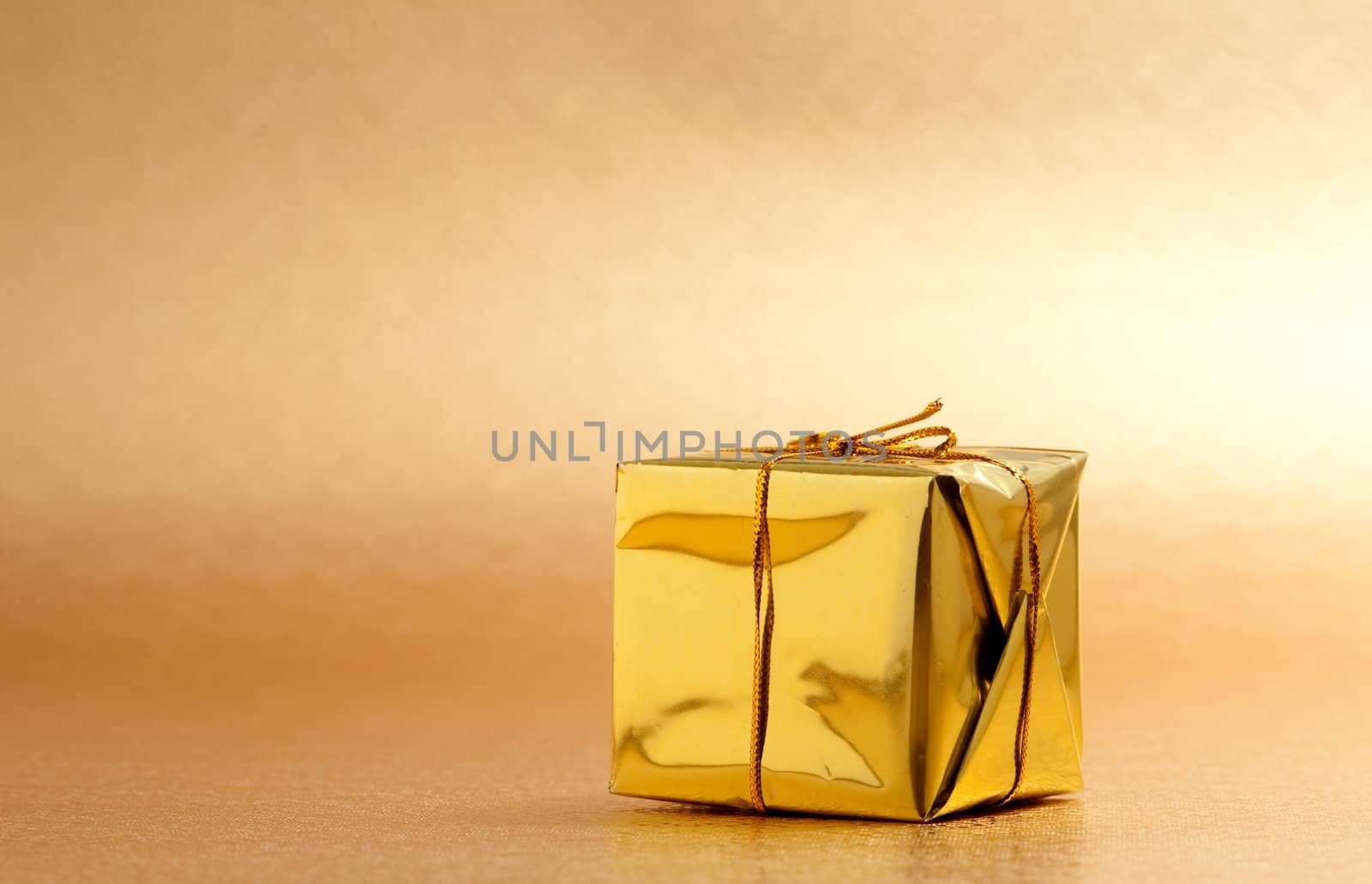 Beautiful gold gift box with gold background
